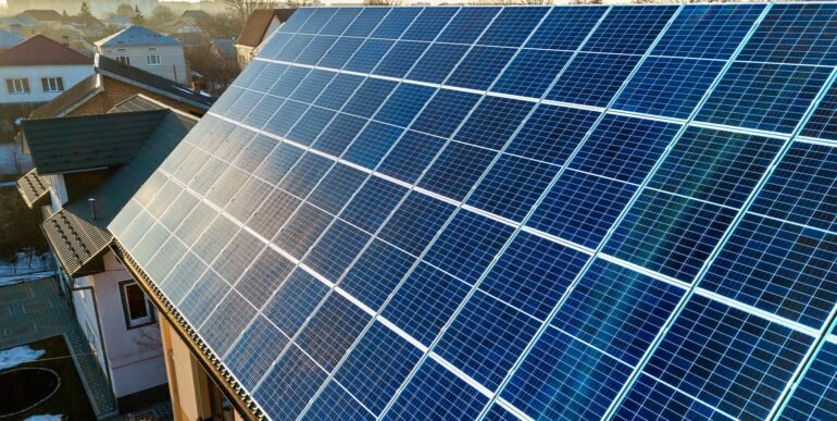 aerial-view-new-modern-two-story-house-cottage-with-blue-shiny-solar-photo-voltaic-panels-system-roof-renewable-ecological-green-energy-production-concept aerial-view-new-modern-two-story-house-cottage-with-blue-shiny-solar-photo-voltaic-panels-system-roof-renewable-ecological-green-energy-production-concept